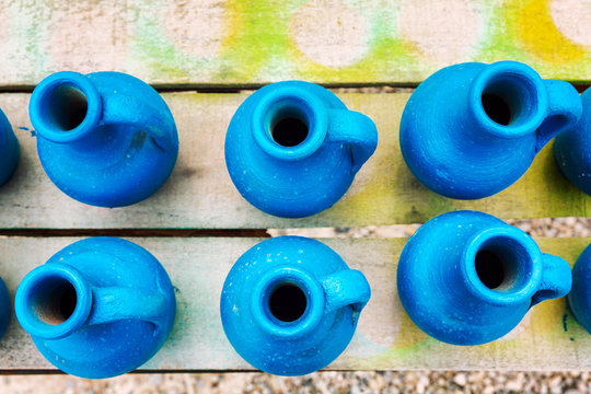 Handmade blue  pitchers on a wooden table. Top view. Close-up.
