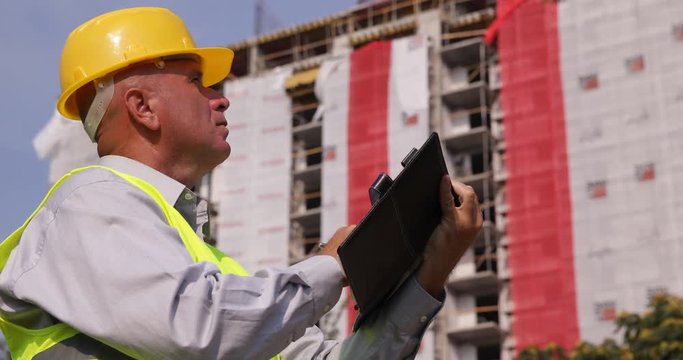 Engineer Inspecting a Building in Construction Take Notes Using Agenda