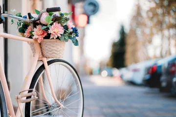 Fotobehang Witte fiets met bloemenmand bij de deur op straat in de stad © B@rmaley