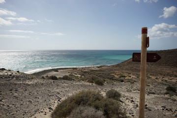 signpost on beach and sea
