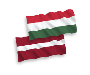 National vector fabric wave flags of Latvia and Hungary isolated on white background. 1 to 2 proportion.