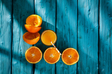 Fresh orange fruits for juice on blue wooden board with shadow. Free space for your decoration and summer time. Healthy nutrition. 
