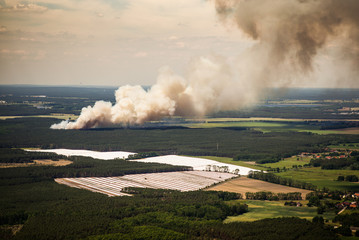 Fototapeta premium Smoke clouds and fire spread of a fire in the trees / forest - aerial view - forest fire 