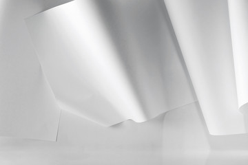 a white wall with curved paper attached to it.