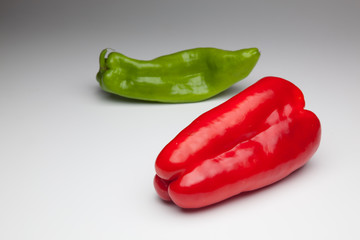Pimiento rojo y pimiento verde sobre fondo blanco
