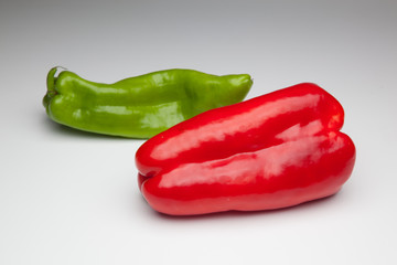 Pimiento rojo y pimiento verde sobre fondo blanco