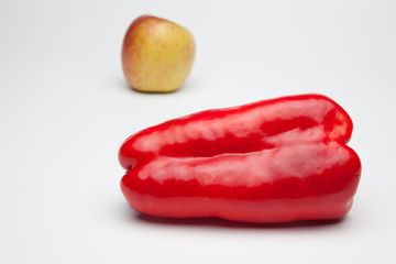 Pimiento y una manzana, sobre fondo blanco