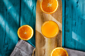 Fresh orange fruits for juice on blue wooden board with shadow. Free space for your decoration and summer time. Healthy nutrition. 