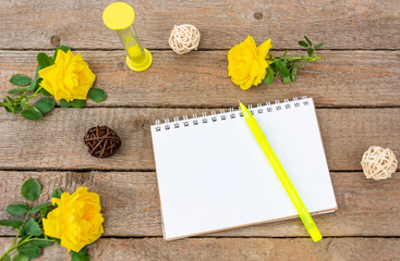 Hourglass, an empty notebook for records, a pen and a rose on the background of wooden boards. Vintage, Flat Lay, Copy space, Mock up