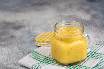 Smoothie with tropical fruits: mango, banana, avocado, chia seeds in a glass jar