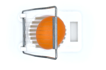 Kitchen device for grinding eggs. White background, isolate. Crude egg in an egg-cutter, top view.