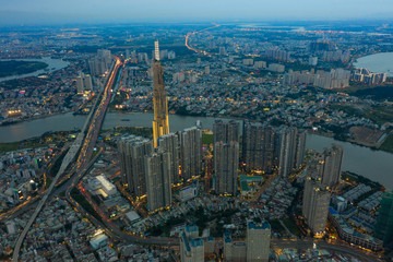 Fototapeta premium Top View of Building in a City - Aerial view Skyscrapers flying by drone of Ho Chi Mi City with development buildings, transportation, energy power infrastructure.