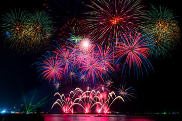 Amazing beautiful colorful fireworks display on celebration night, showing on the sea beach with...
