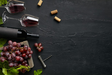 Top view of tasty fruit plate with the wine bottle and glasses on the black stone on a kitchen...