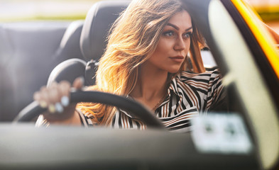 female driver in a sports yellow convertible car