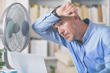 Man suffers from heat in the office or at home