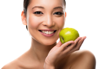 cheerful asian woman holding green apple, isolated on white