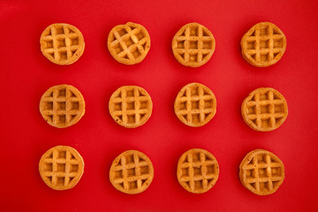 round little Viennese waffles on a red background top view. Sweet background