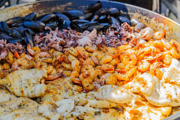 Seafood barbecue outdoors. Fresh mussels, shrimps, octopus, calmyars at grill pan.