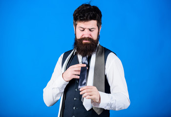 For completing professional look. Fashionable hipster choosing necktie. Bearded hipster trying on a...