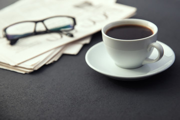 glasses on newspapers with coffee