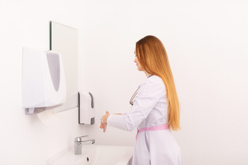 Young female doctor washing her hands befor patient admission in new clinic office. Helthcare concept
