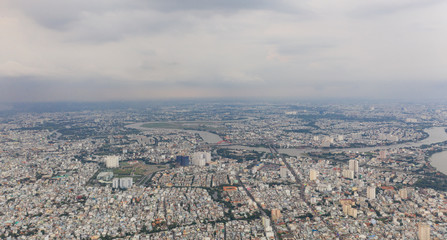 Obraz premium Top View of Building in a City - Aerial view Skyscrapers flying by drone of Ho Chi Mi City with development buildings, transportation, energy power infrastructure.