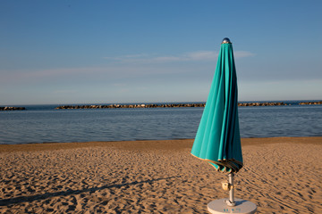 Italian summer on the Adriatic Sea: tyipical italian Riviera Romagnola beach clubs with sunbeds and beach umbrellas with typical vintage colors and look