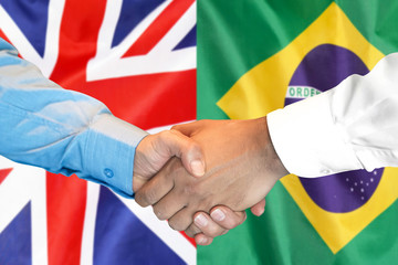 Business handshake on the background of two flags. Men handshake on the background of the Brazil and United Kingdom flag. Support concept