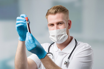 Scientist with medical face mask and blood probe