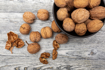 walnuts in black bowl on wooden background