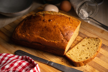 Delicious sponge cake sliced on a wooden surface with ingredients in the background