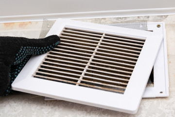 repair service man removing a dirty air filter on a house so he can replace it with a new clean....
