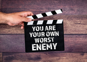 You Are Your Own Worst Enemy. Hand holding movie clapper