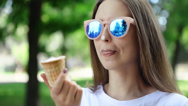 Closeup portrait Summer background. Young woman eating ice cream 