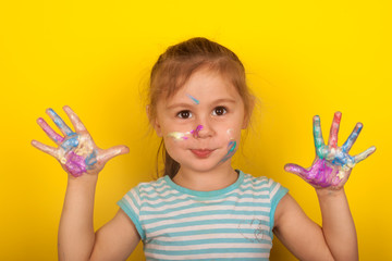 Little girl on a yellow background shows hands drawn