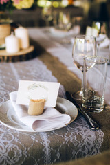Beautiful decorated elegant wedding table for dinner with floral white bouquets, candlesticks and a white tablecloth glasses and porcelain plates