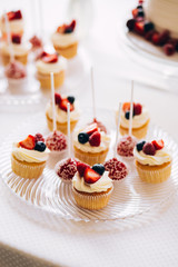 Beautiful cake covered with icing cream, summer berries on the top. Style and food photography