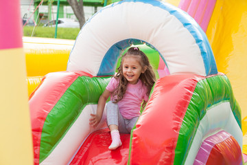 A cheerful child plays in an inflatable castle