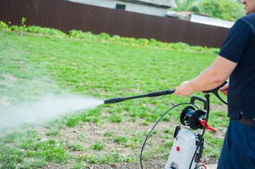 A man hoses a portable car for washing the car i