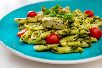 close-up of plate of pasta and chicken with lettuce