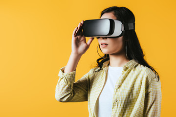 girl using Virtual reality headset, isolated on yellow