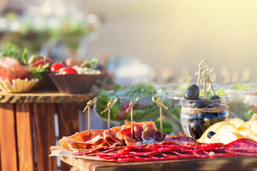 Beautifully decorated catering banquet table with different food snacks and appetizers with sandwich, caviar, fresh fruits on corporate christmas birthday party event or wedding celebration