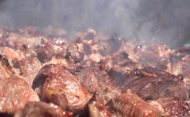 Grilled kebab cooking on metal skewer. Roasted meat cooked at barbecue. BBQ fresh meat chop slices. Traditional eastern dish, shish kebab. Grill on charcoal and flame, picnic, street food 