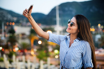 Happy young woman taking selfie on vacation