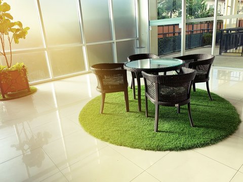 interior furniture, table set for dining decorating with artificial grass circle shape on the floor, interior design decoration concept in the building. 
