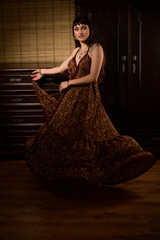 Fototapeta premium Young girl dancer and singer in gypsy dress dancing and posing on stage