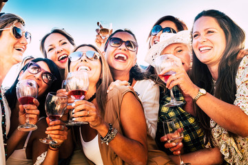 Beautiful women in group celebrate the friendship  with some wine glass. Nine caucasian people...