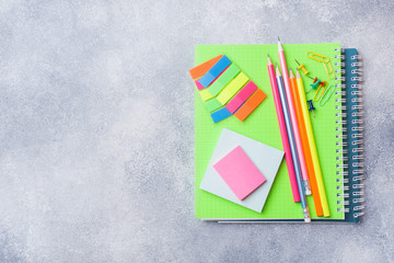 School supplies, notebooks pencils on grey background with copy space.