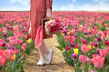 Rolgordijnen Beautiful young woman in tulip field on spring day © Pixel-Shot